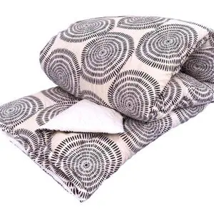 Kehä päiväpeitto; vaaleanharmaalla pohjalla tummista viivoista koostuva kehäkuvio. Päiväpeiton nurjapuoli valkoinen.