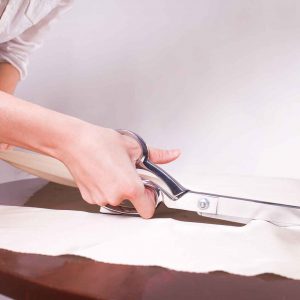 Vormu valmistaa tuotteita myös mittatilaustöinä; saksilla leikataan kangasta käsin.