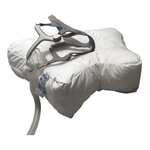 Valkoinen Uniquu uniapneatyyny ja uniapneamaski tyynyllä.