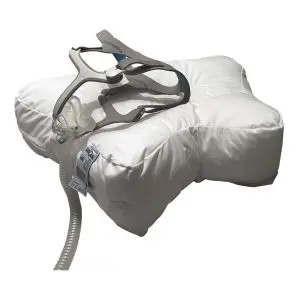 Valkoinen Uniquu uniapneatyyny ja uniapneamaski tyynyllä.