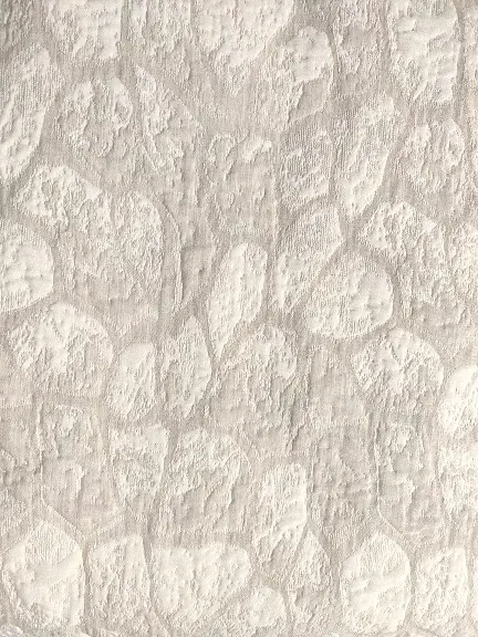 Hiidenkivi beige -kuosi läheltä. Kuin vaaleita kiviä beigellä taustalla.