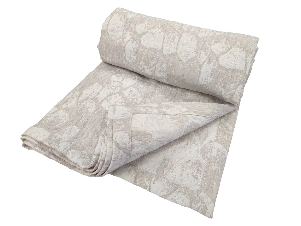 Hiidenkivi päiväpeitto värissä beige. Kauniit jiiriin ommellut kulmat ja päiväpeitto on käännettävä.